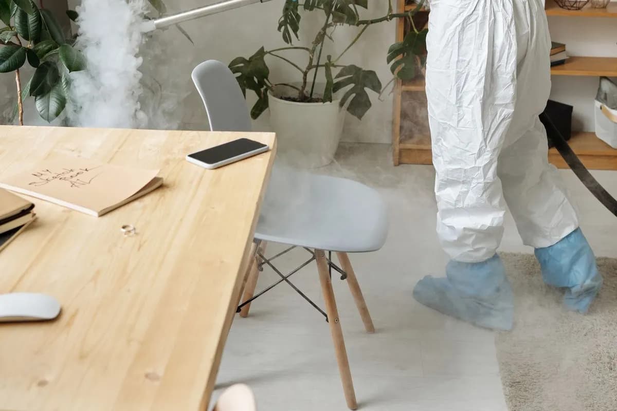 Désinfection de bureaux par un technicien en équipement de protection