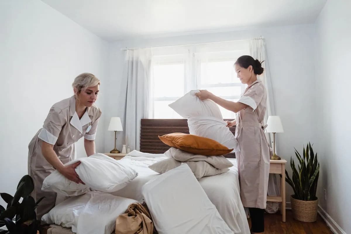 Personnel d'hôtel préparant une chambre