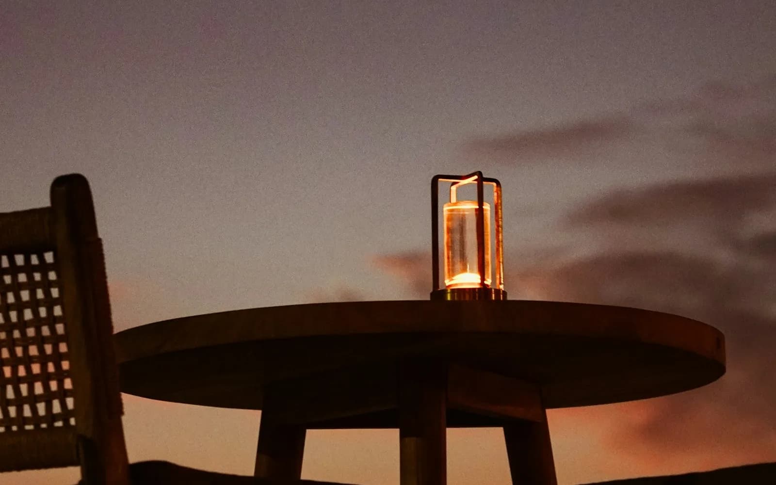 Terrasse aménagée au crépuscule, table et lanterne